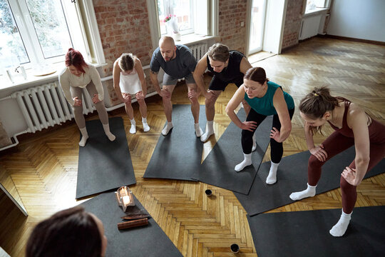 Yoga class doing yoga while taking part in a wellness class indoors