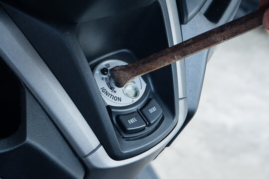 rusty iron tool attempting to break into a scooter ignition switch lock