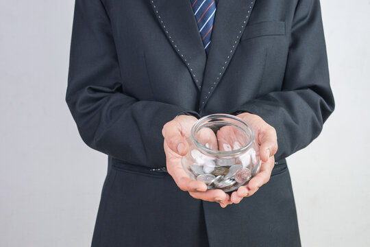 Businessman Showing Coin Filled Glass Jar