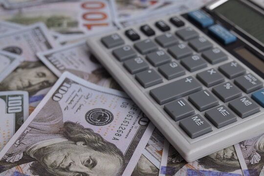 Close Up of Electronic Calculator Placed on Scattered Hundred Dollar Bills