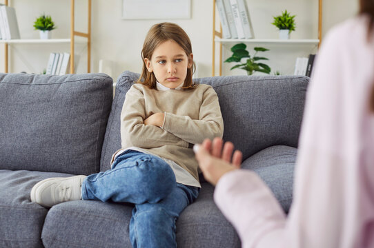 Professional female therapist or psychologist woman working with depressed, frustrated upset little child boy trying to help with his problem. Mental health and psychotherapy concept.