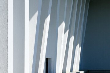 Fototapeta premium Modern White Building Exterior with Strong Geometric Shadows and Architectural Lines