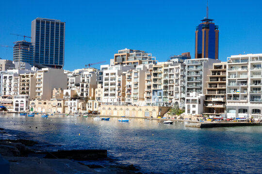 Traditional maltese boats floating peacefully in spinola bay, st. Julian's, malta