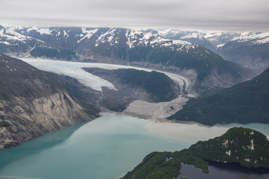 Aerial view of a glacier, lake  snow capped mountains in Glacial Bay