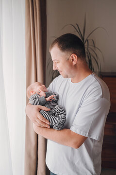 Happy father holds his newborn baby son