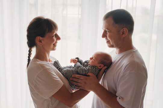Mother and father lovingly hold newborn baby