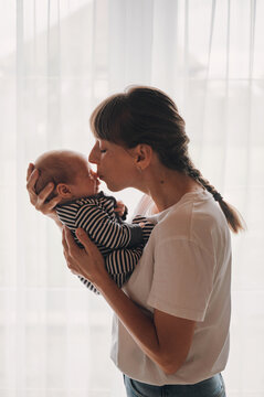 Tender mother kissing her newborn baby's nose
