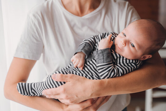 Mother lovingly cradles her newborn baby boy