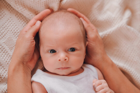 Parent gently holding newborn baby's head