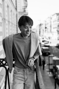Woman with short hair smiling on a balcony, Room and a Half