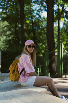 Young woman wearing baseball cap looks over shoulder
