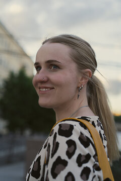 A smiling young blonde woman looking away