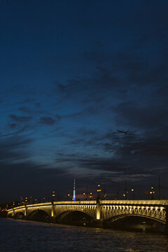Trinity Bridge illuminated over Neva River at twilight