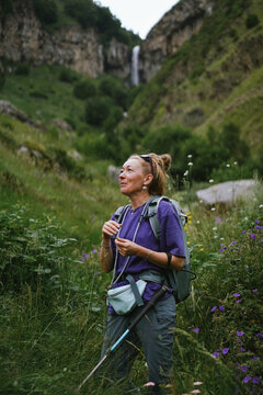 Mature woman pauses to enjoy mountain scenery