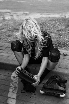 Young woman with wavy blonde hair putting on skates