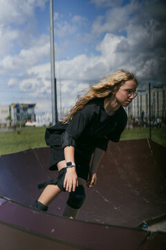 Blonde girl with glasses on skatepark ramp