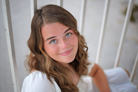 Teenage girl with blue eyes and freckles smiling