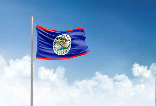 Belize flag waving in beautiful sky.