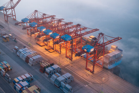 Cranes loading containers onto a cargo ship at a port in Long Beach