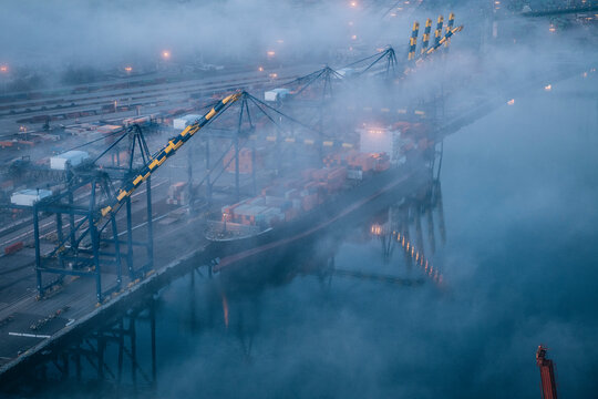 Cargo container ship docked in foggy shipping port at Long Beach