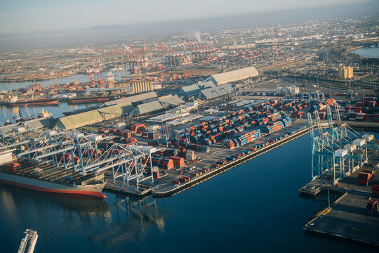 Aerial view of container port with cargo ships and cranes in a beach