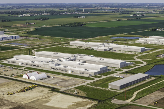 Aerial view of a large data center complex surrounded by expansive green agricultural fields and rural landscape in DeKalb, Illinois, United States.