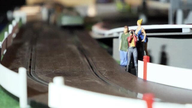 Small model race car near miniature spectators