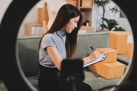 Woman recording live stream preparing packages for online selling