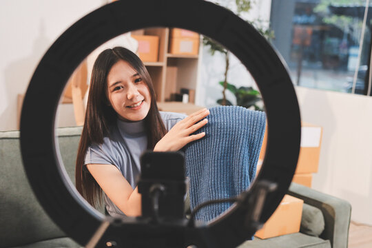 Woman recording live stream preparing packages for online selling