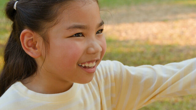Close-up Portrait of a Happy Thai Girl Smiling Outdoors