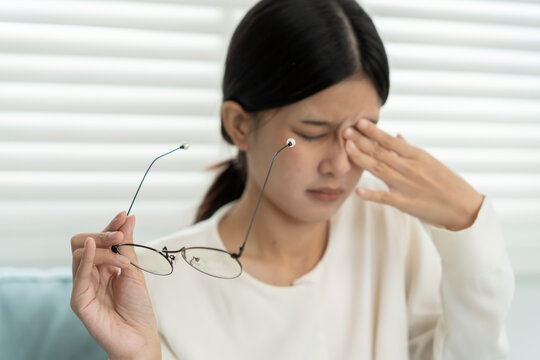 Eye problems, Asian women close eye for relax. eye irritation, eye rubbing, dry, eye pain after read book a long time, migraine, headache, blurred vision, photophobia, small words