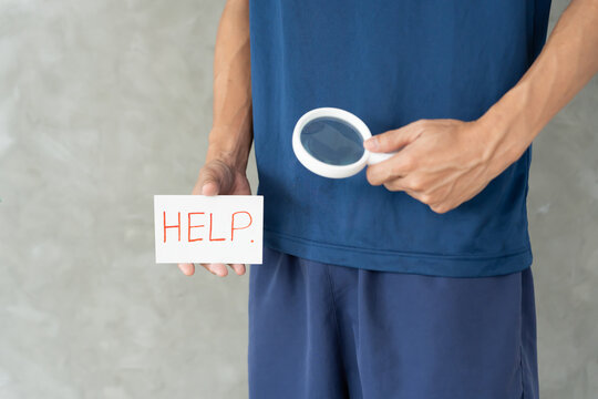 Man uses magnifying glass for size problems, discomfort from disease and inflammation. Venereal, testicular cancer. bladder problems, erectile dysfunction, premature ejaculation, prostate cancer.