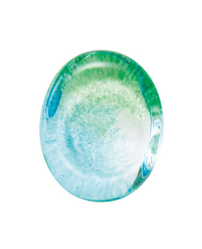 Green and blue glass paperweight with bubbles on white background