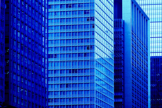 Dense pattern of illuminated modern skyscraper facades, symbolizing digital transformation, finance, and technology.