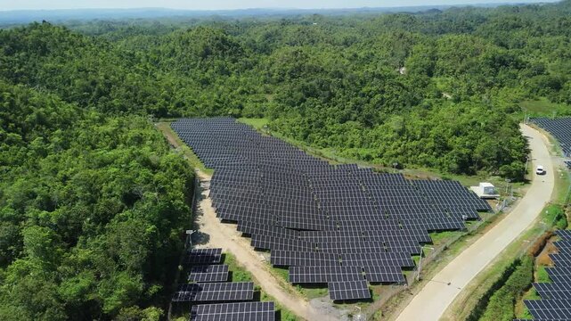 Drone ascends and pulls back over solar panel arrays, access roads, and surrounding hills at Sikatuna Solar Power Plant in Bohol