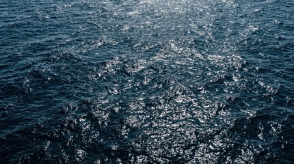 Fototapeta premium Open ocean surface with rippling waves and sunlight reflections, shimmering blue water and glinting highlights creating expansive marine seascape mood