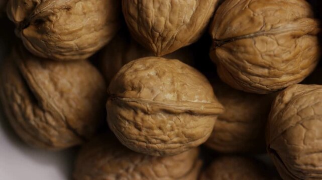 Extreme close up panning over textured whole walnut shells