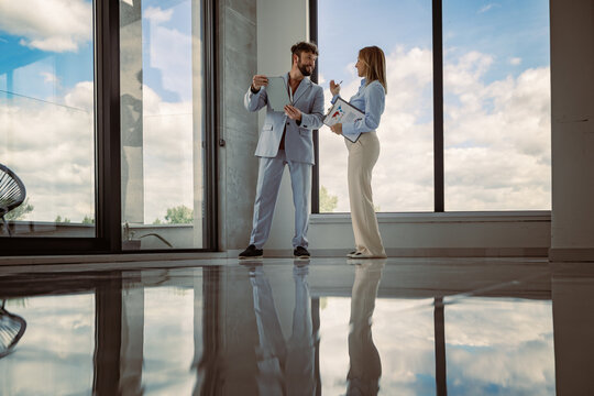 Business meeting in a modern office space with large windows and reflections on the floor