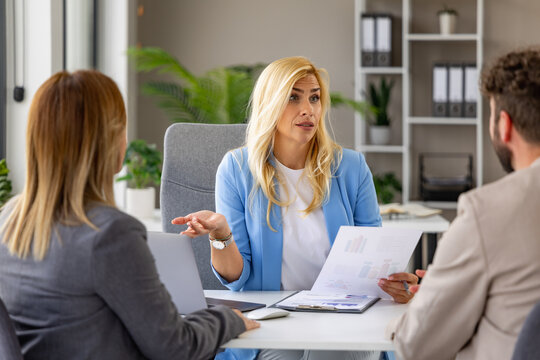 Business meeting with a woman discussing reports in a modern office setting