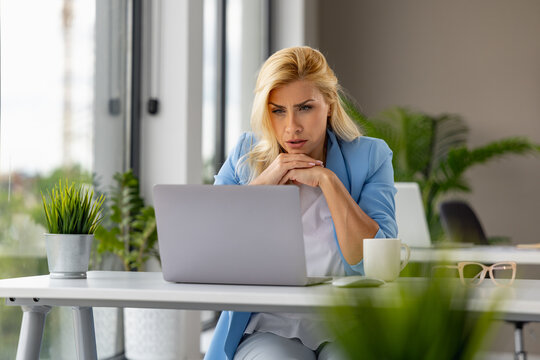 Woman working on laptop in modern office 
