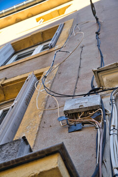 Messy cable installation on an old house facade.