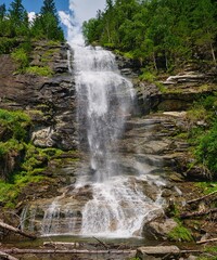 Obraz premium Vertical view of Melnikfall waterfall cascading down a rocky cliff near Berghotel Malta, Austria