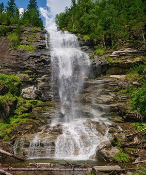 Vertical view of Melnikfall waterfall cascading down a rocky cliff near Berghotel Malta, Austria