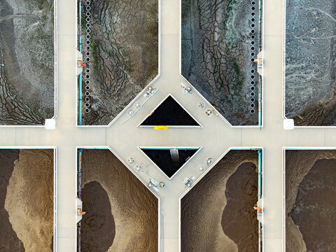 Aerial view of American Fork Wastewater treatment Plant showing aerated bioreactors and settling tanks with textured sludge and water infrastructure in American Fork, Utah, United States.