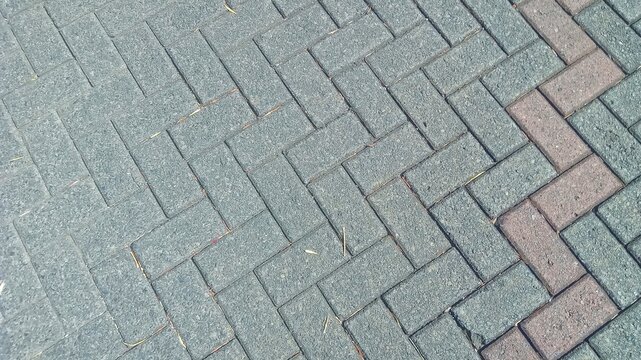 Paved Brick Pathway. A close-up of interlocking brick paving stones ideal for landscape design and outdoor flooring.
