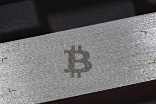 Close-up of Bitcoin Symbol Etched on Brushed Metal Surface