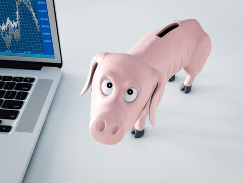 Thin piggy bank besides laptop with stock-market price looking reproachfully at viewer