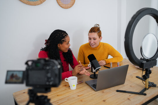 Content creators recording a podcast with camera and ring light indoors