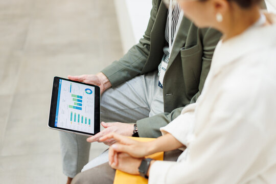 Businessman and businesswoman analyze financial charts indoors