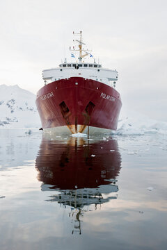 South Atlantic Ocean, Antarctica, Antarctic Peninsula, Gerlache Strait, Paradise Bay, Polar Star icebreaker cruise ship on sea, mountain in background